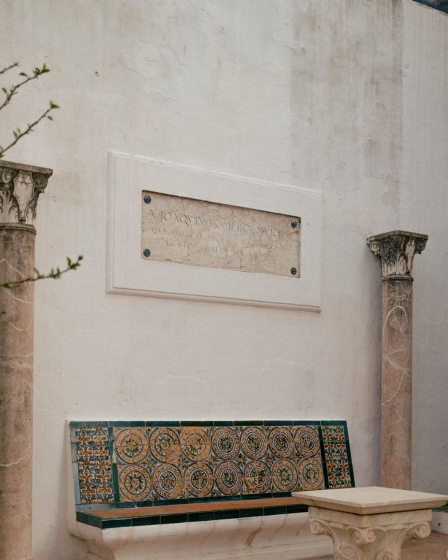 Patio interior de una casa sevillana con arcos de herradura, fuente y zócalo de azulejos