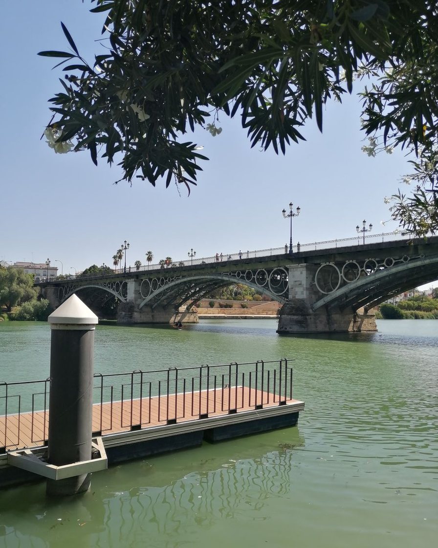 El Guadalquivir a su paso por Sevilla, con un puente de hierro y los muelles a ambas orillas