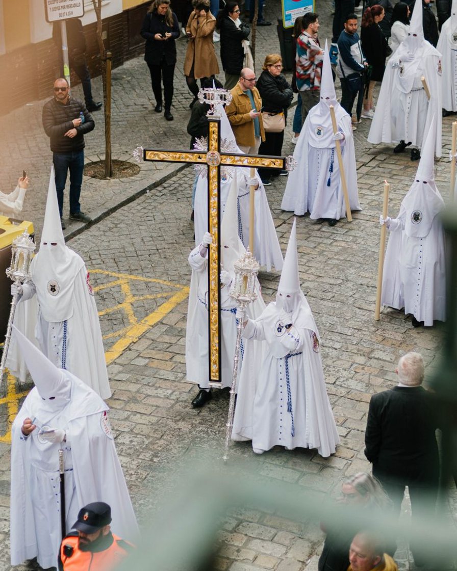 Salón de actos con un cartel de gran formato cubierto por un paño sobre un caballete, junto a un atril con micrófono, minutos antes de una presentación en Sevilla